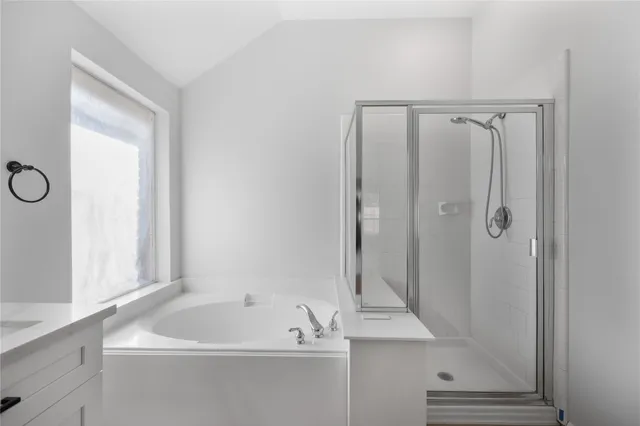 a bathroom with a tub a sink and a window