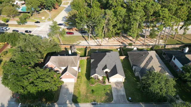 an aerial view of residential houses with outdoor space and trees all around