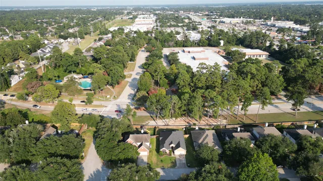 an aerial view of residential houses with outdoor space and trees
