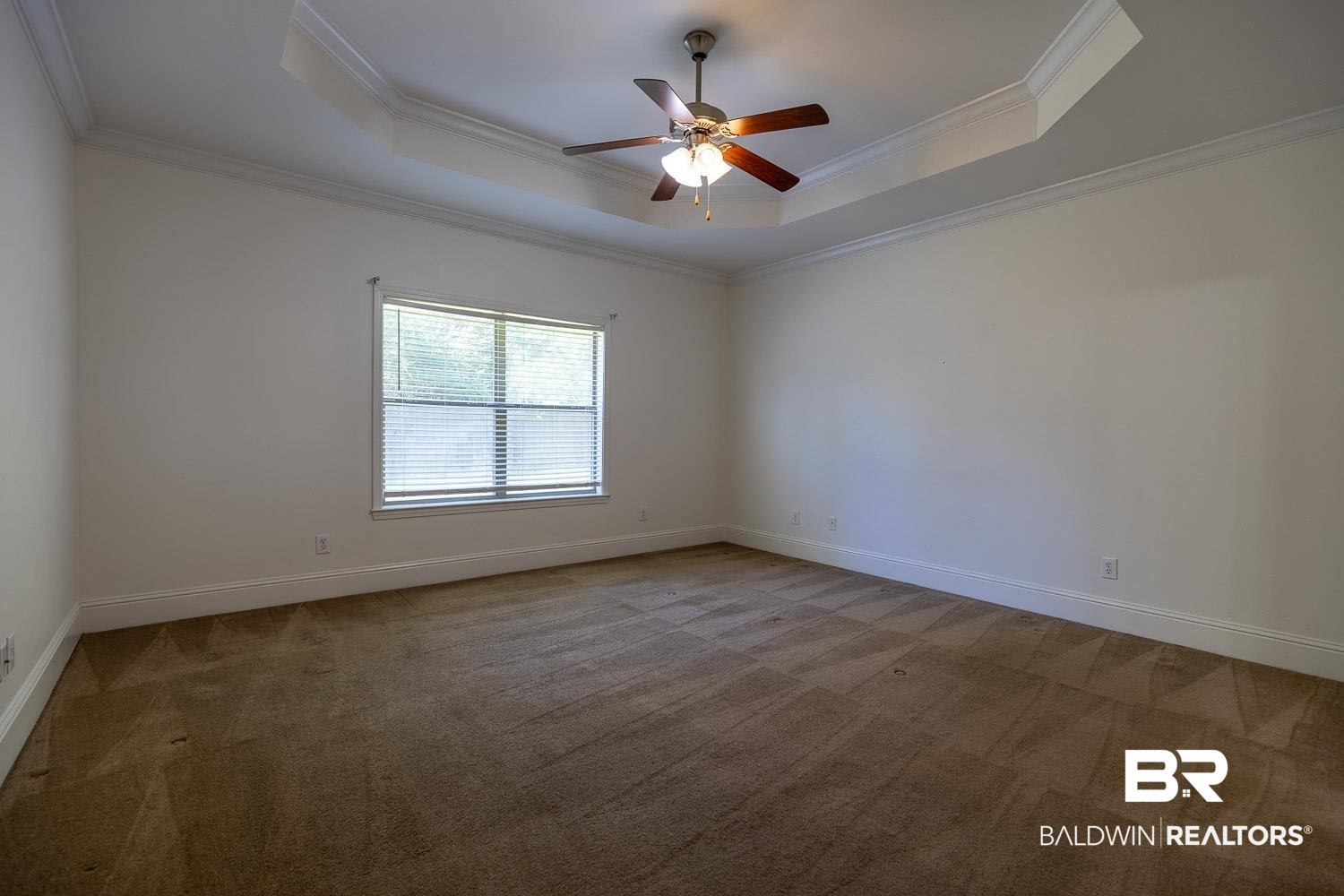 101 Normandy Street Fairhope, AL 36532 - Photo 10 of 18 Empty room with crown molding, a raised ceiling, light colored carpet, and a ceiling fan
