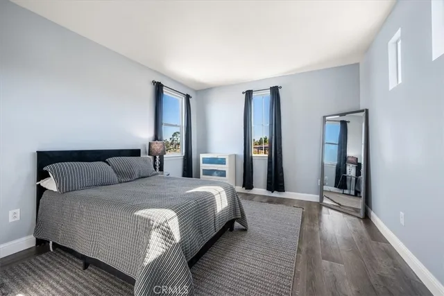 a bedroom with a bed and a flat tv screen next to a window