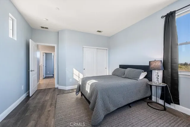a view of a hallway with wooden floor and a bathroom
