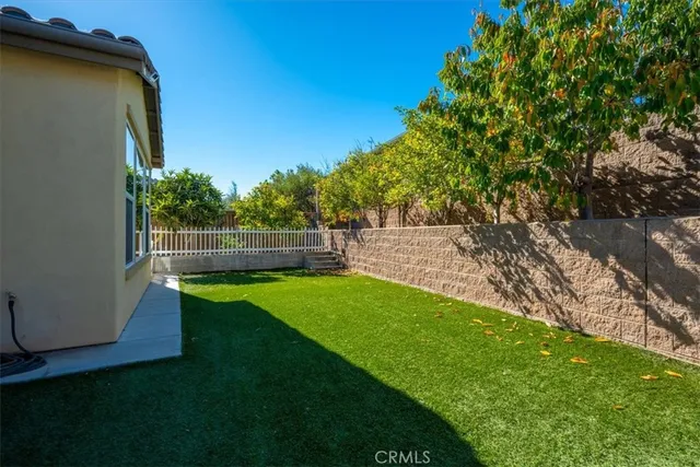 a view of a chair and table in the back yard of the house