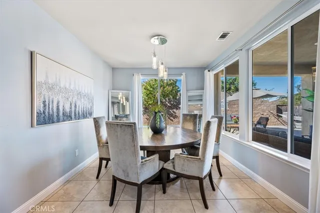 a kitchen with a dining table chairs cabinets and stainless steel appliances
