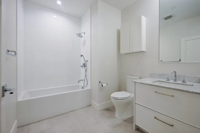 a bathroom with a granite countertop toilet a sink and a bathtub