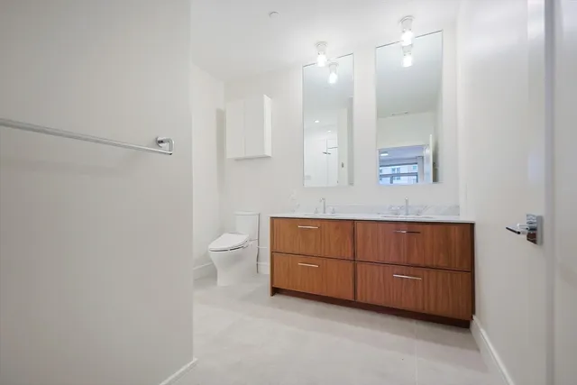 a bathroom with a sink a toilet and a mirror