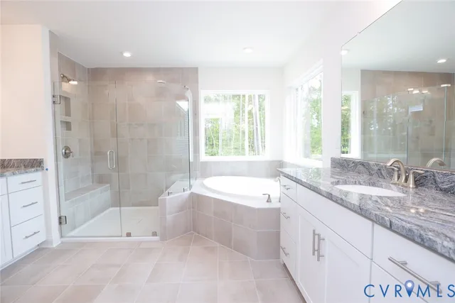 a bathroom with a granite countertop bathtub shower sink and mirror