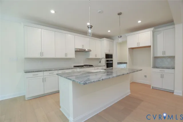 a kitchen with granite countertop white cabinets and white appliances