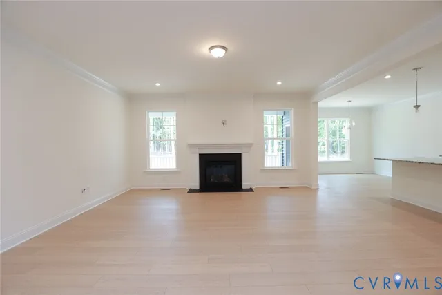 an empty room with windows and fireplace