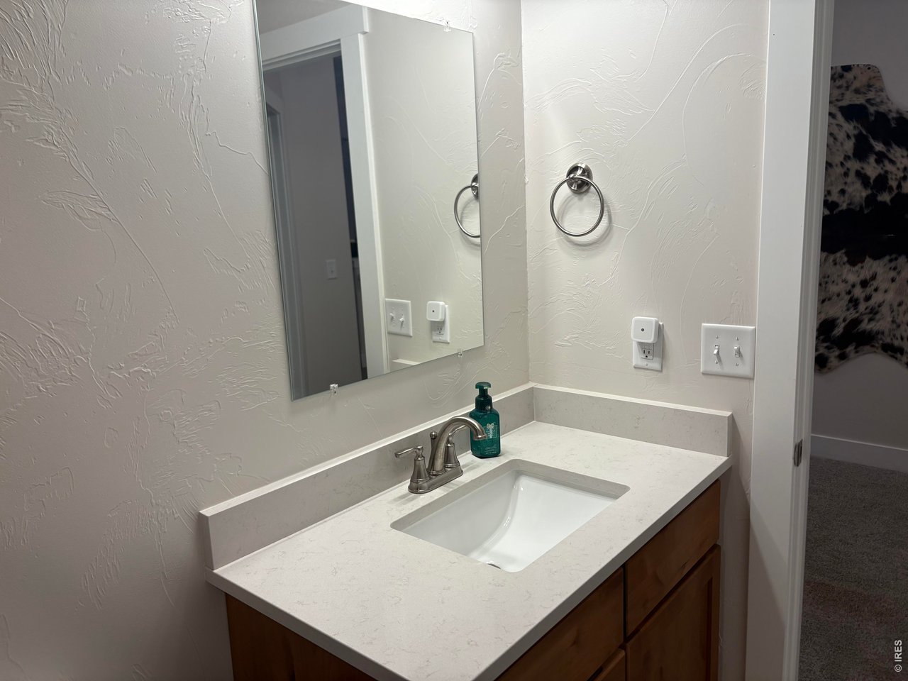 102 7th Avenue Wiggins, CO 80654 - Photo 13 of 17 a bathroom with a sink and a mirror