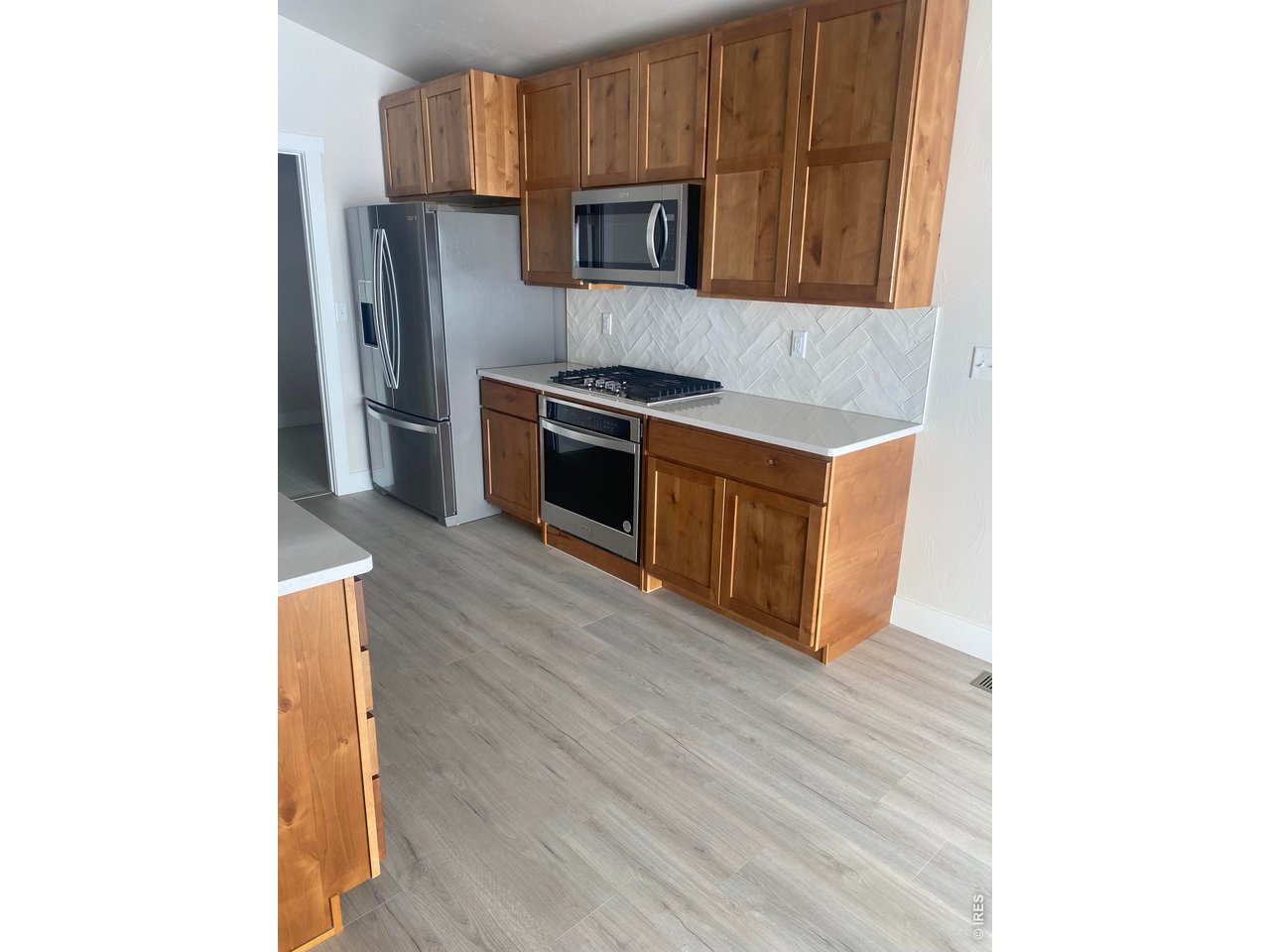 102 7th Avenue Wiggins, CO 80654 - Photo 3 of 17 a kitchen with stainless steel appliances granite countertop a stove a microwave and a refrigerator