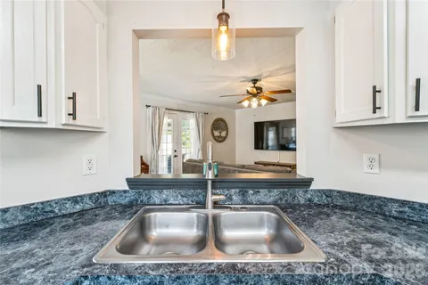 a kitchen with granite countertop a sink stainless steel appliances and cabinets