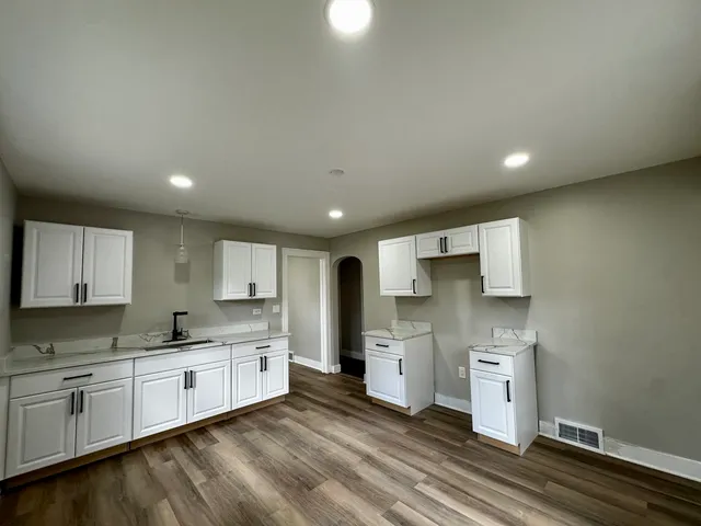 a kitchen with granite countertop a sink cabinets and stainless steel appliances