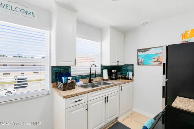 a kitchen with a refrigerator and a stove top oven