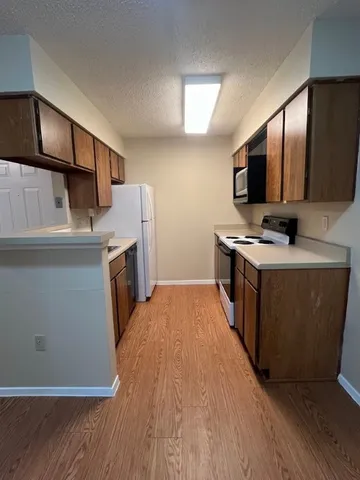 a kitchen with stainless steel appliances a stove top oven a sink and a refrigerator