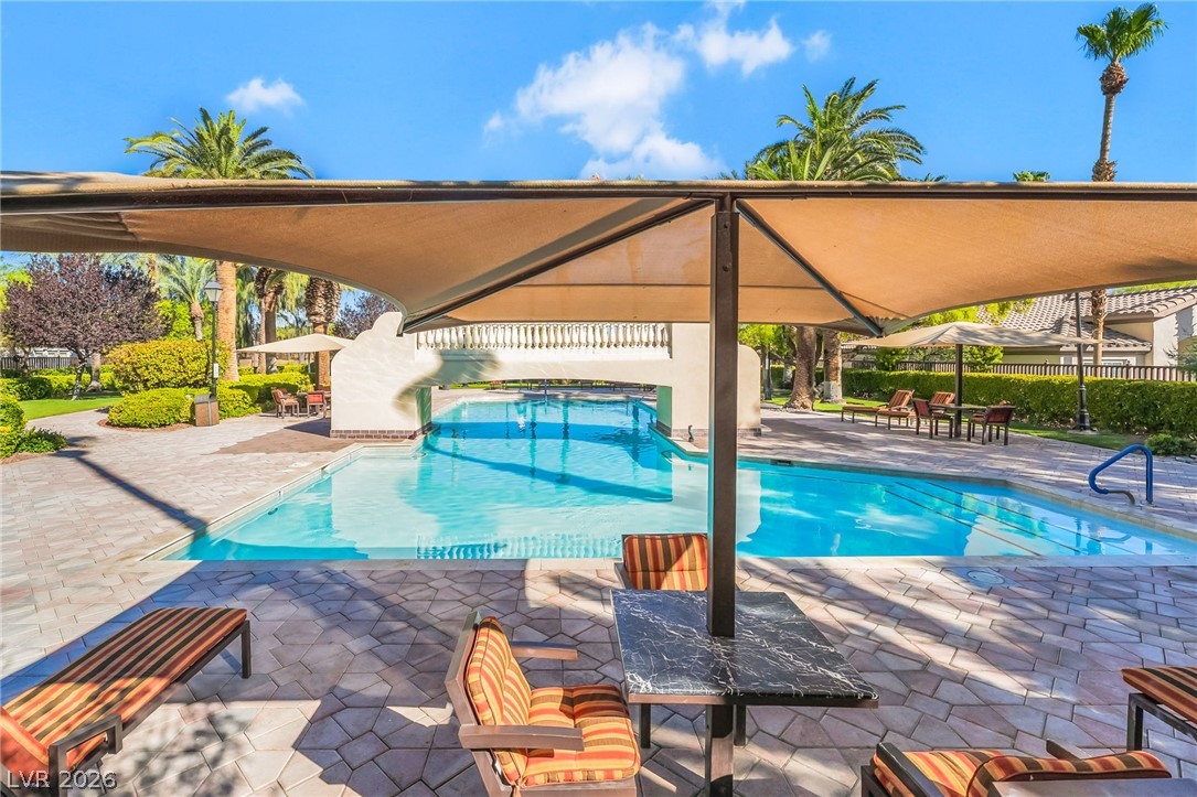 2050 West Warm Springs Road, Unit 2411 Henderson, NV 89014 - Photo 35 of 37 An inviting pool area with shaded seating and lush landscaping creates a relaxing oasis.