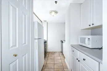 a kitchen with stainless steel appliances granite countertop white cabinets and a stove top oven