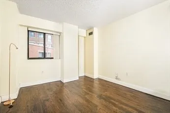 an empty room with wooden floor and mirror
