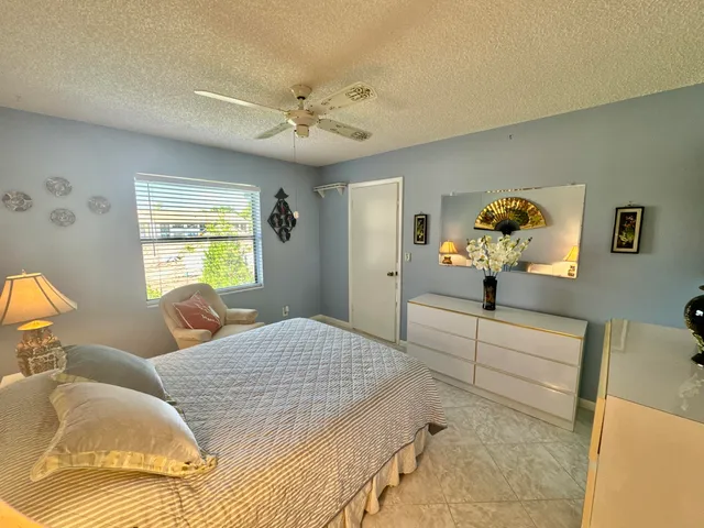 a bedroom with a large bed and ceiling fan