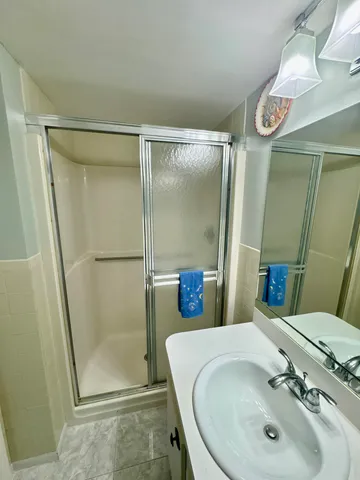 a bathroom with a sink mirror and shower