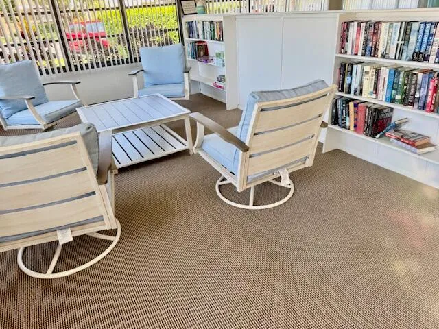a living room with furniture and a book shelf