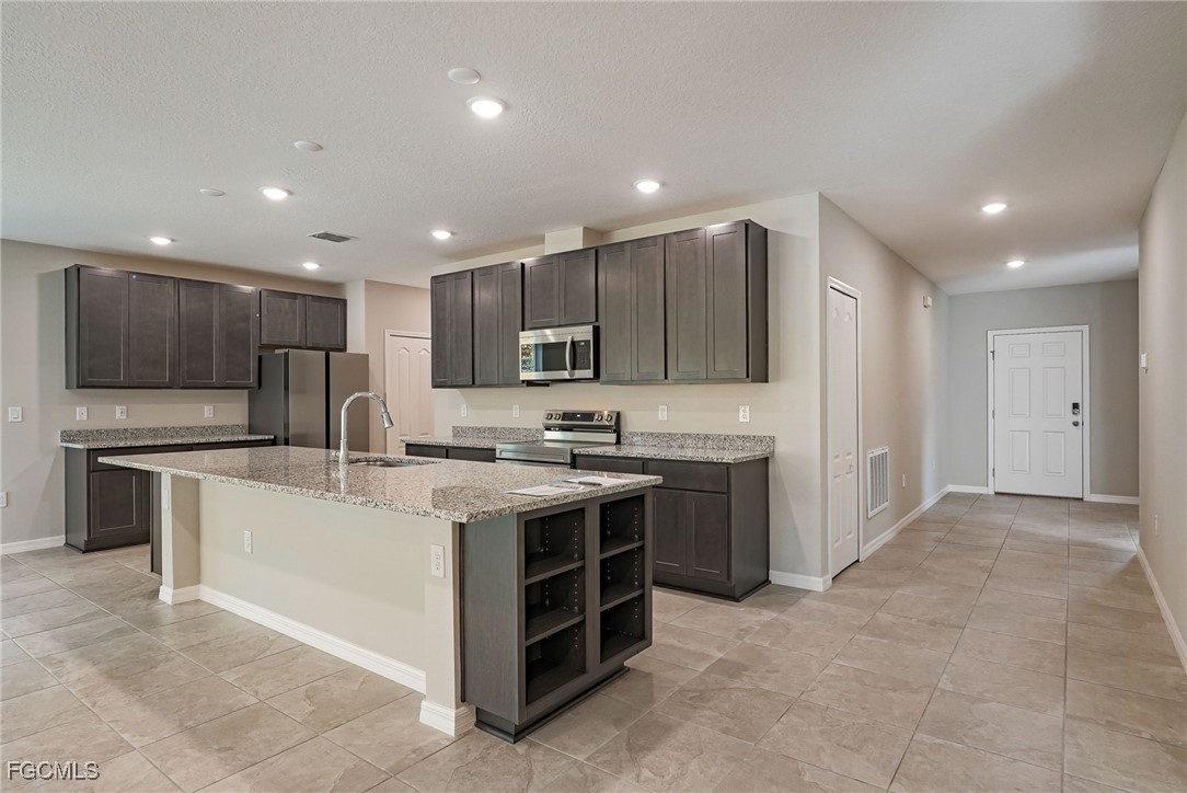 3023 North Lakewood Road LaBelle, FL 33935 - Photo 17 of 39 a large kitchen with stainless steel appliances granite countertop a large counter top a stove a sink and a refrigerator