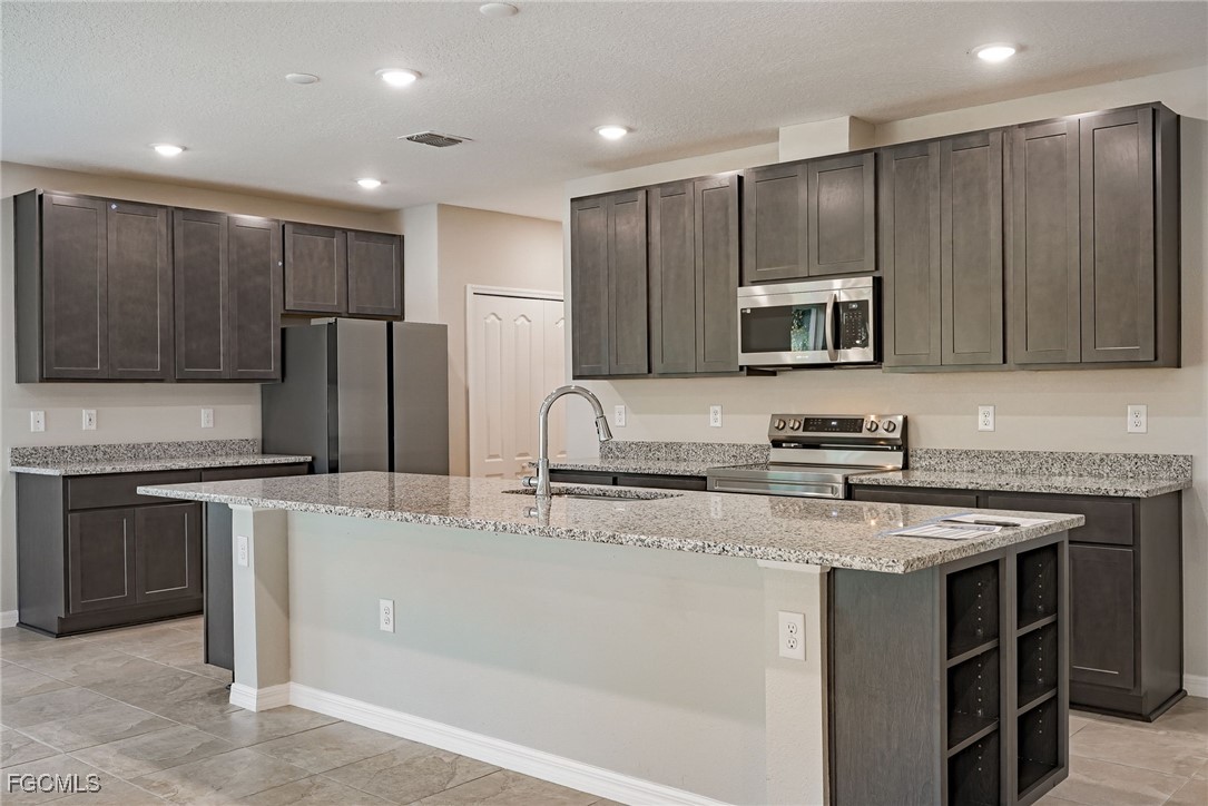 3023 North Lakewood Road LaBelle, FL 33935 - Photo 23 of 39 a kitchen with kitchen island granite countertop stainless steel appliances and cabinets