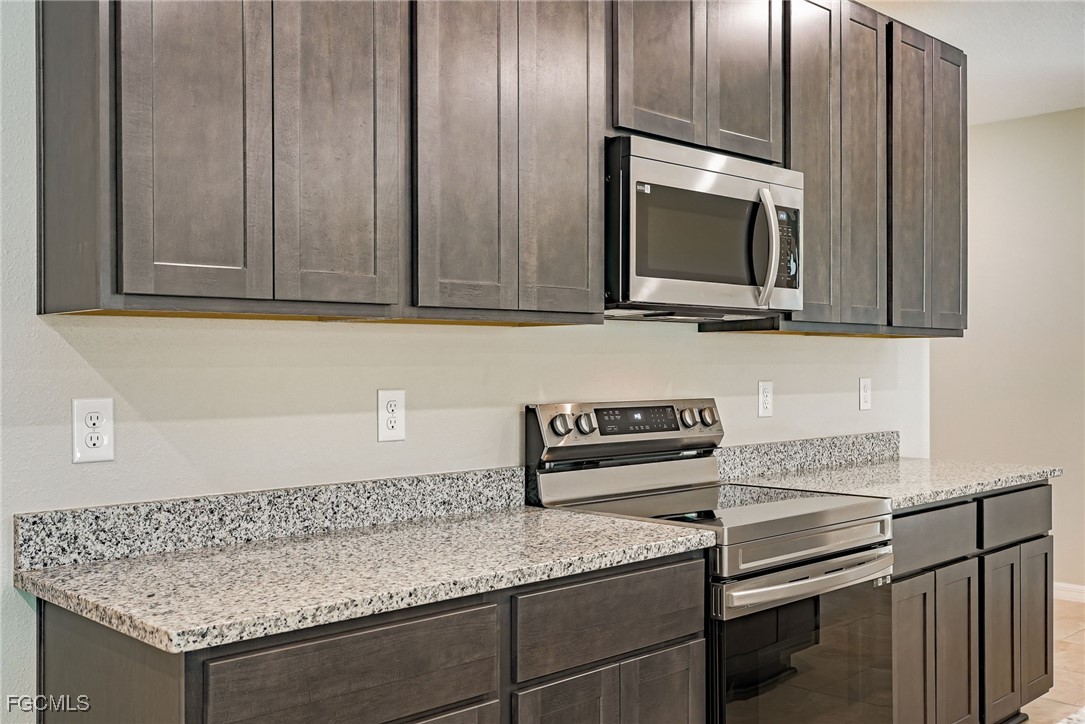 3023 North Lakewood Road LaBelle, FL 33935 - Photo 24 of 39 a kitchen with granite countertop a sink cabinets and stainless steel appliances