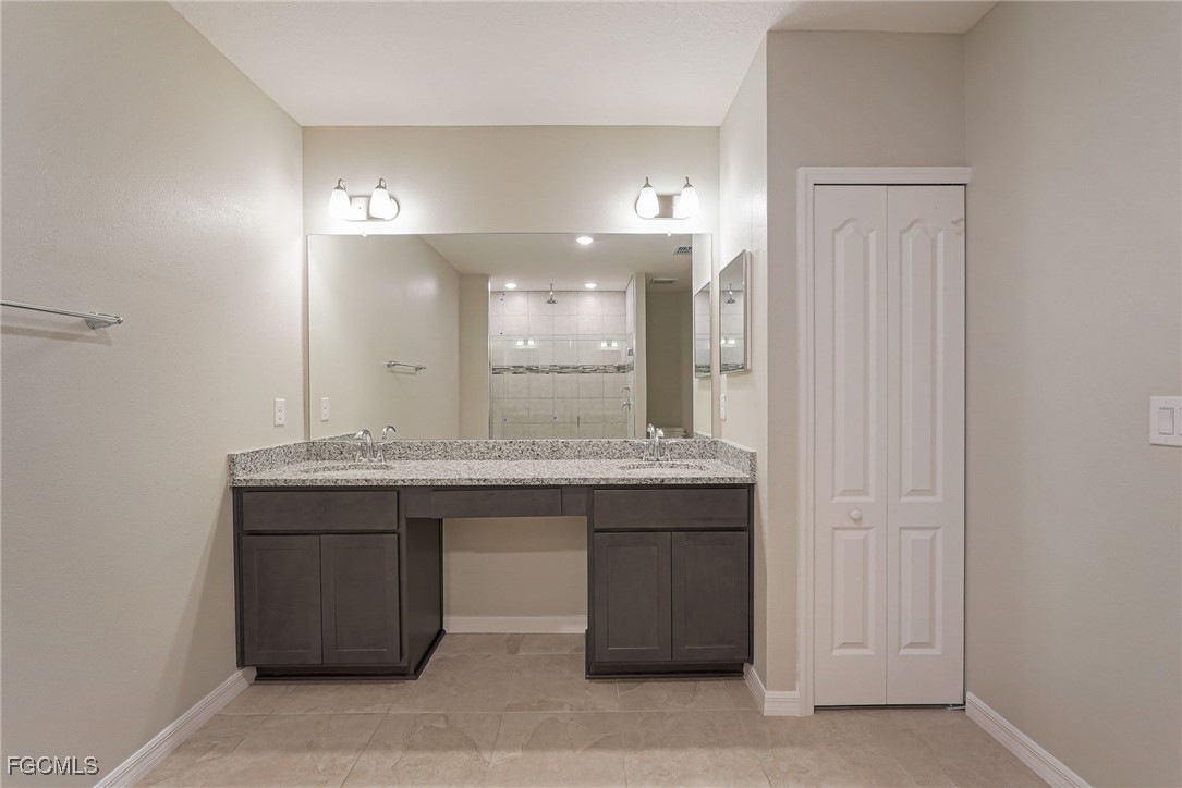 3023 North Lakewood Road LaBelle, FL 33935 - Photo 30 of 39 a bathroom with a granite countertop sink a mirror and a shower