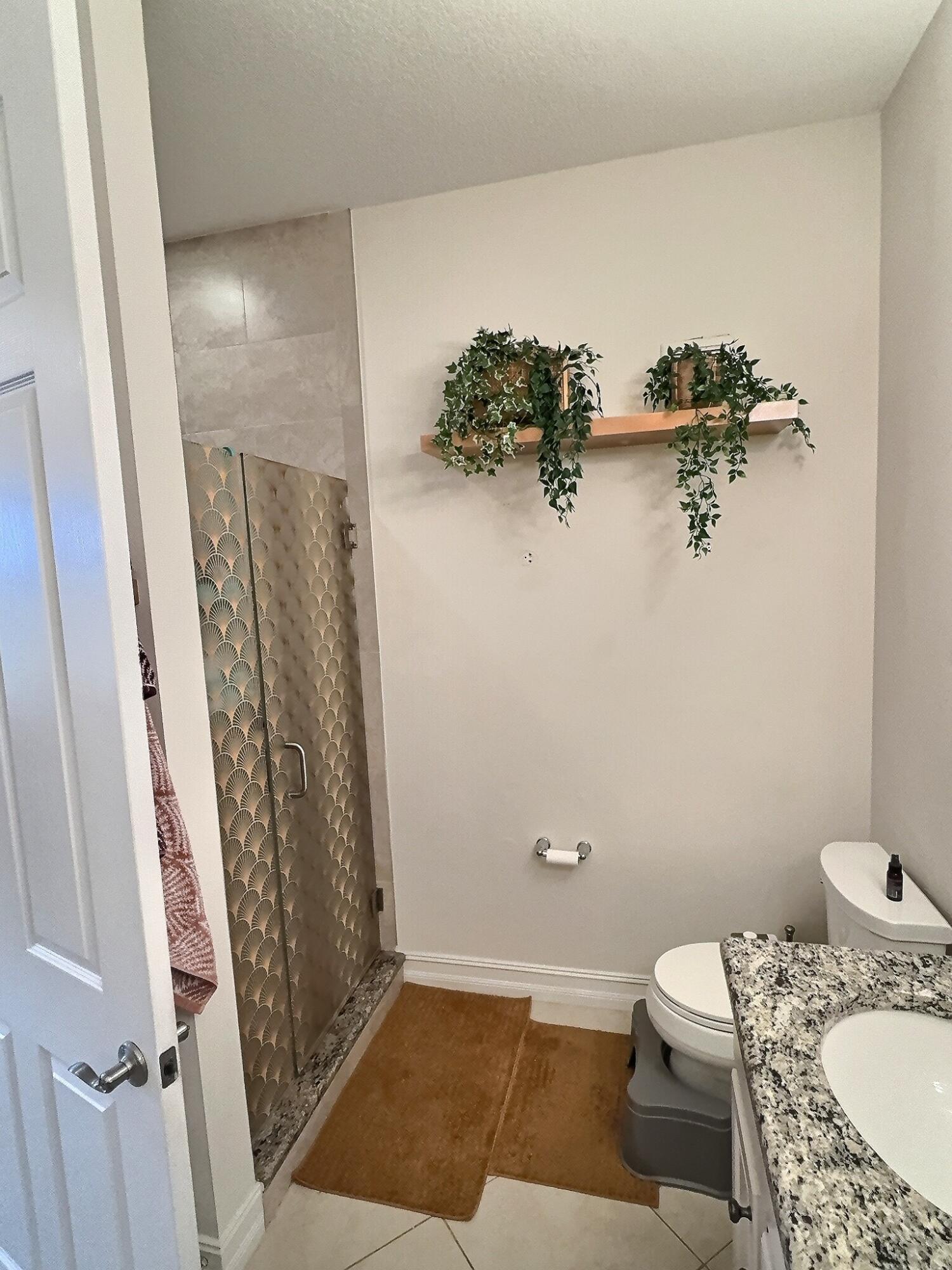 10320 Southwest Stephanie Way, Unit 7210 Port St. Lucie, FL 34987 - Photo 11 of 15 a bathroom with a granite countertop sink and a mirror