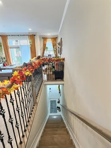 a view of a hallway with wooden floor and staircase
