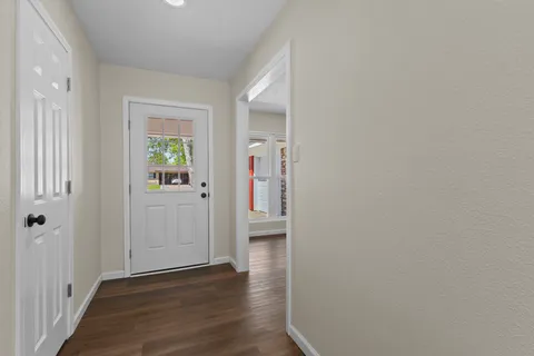 a view of empty room with wooden floor and fireplace
