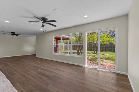 a view of an empty room with a fireplace and a window