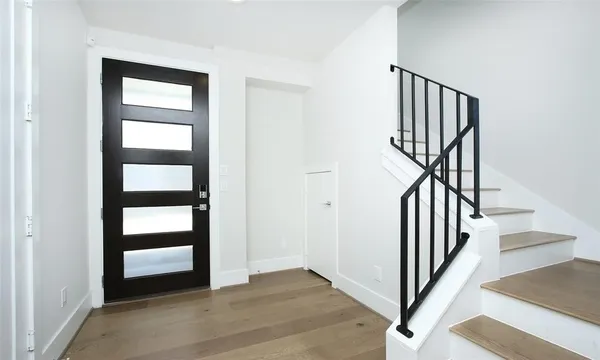an entryway in a room with wooden floor and stairs