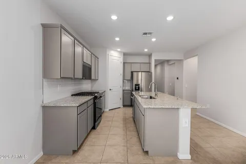 a large kitchen with stainless steel appliances kitchen island granite countertop a sink and cabinets