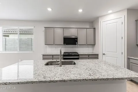 a kitchen with a sink a stove and a microwave