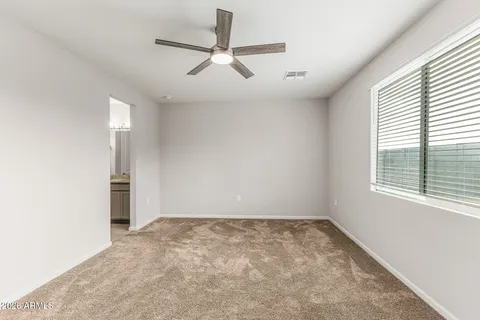 an empty room with a ceiling fan and window