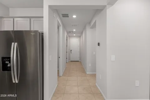 a view of a hallway with stainless steel appliances