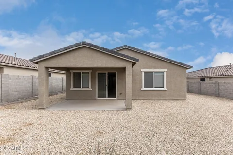a front view of a house with a plants and wooden fence