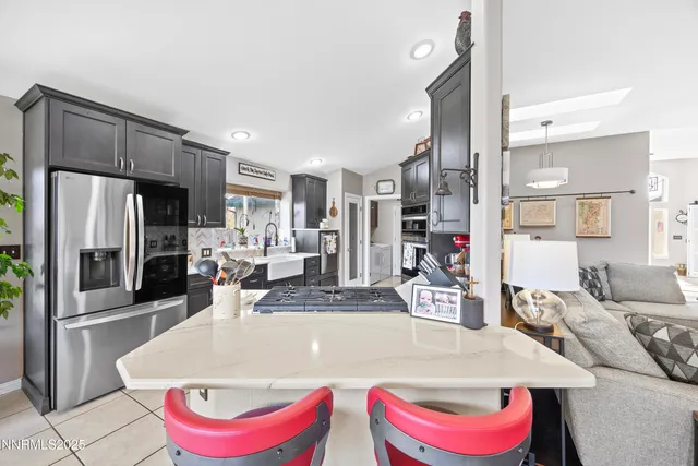 a kitchen with stainless steel appliances kitchen island granite countertop a refrigerator and a stove top oven