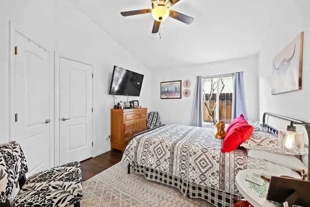 a bedroom with a bed wooden floor and a chandelier