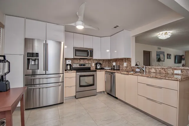 a kitchen with granite countertop white cabinets and stainless steel appliances