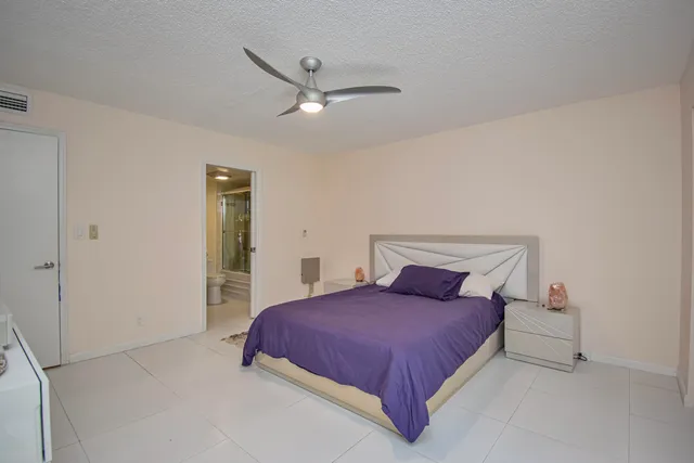 a bedroom with a bed and a ceiling fan