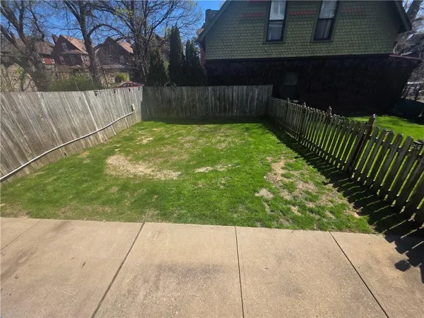 a view of backyard with wooden fence