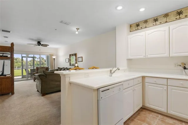 a kitchen with white cabinets and sink