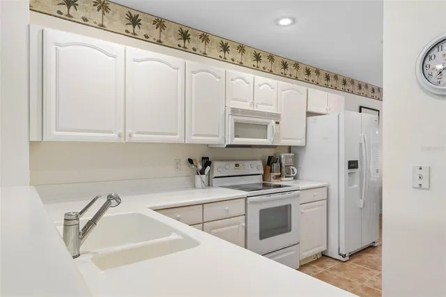 a kitchen with white cabinets and white appliances