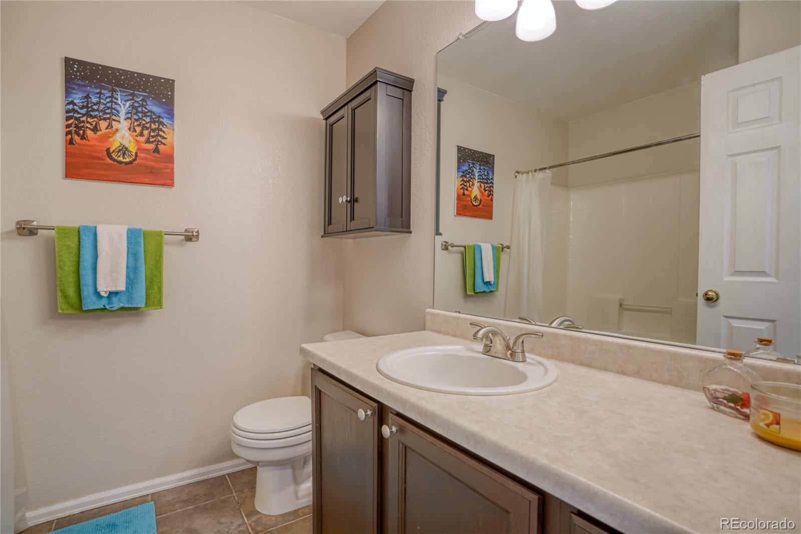 659 Timbervale Trail Highlands Ranch, CO 80129 - Photo 20 of 32 a bathroom with a granite countertop sink a toilet and a mirror