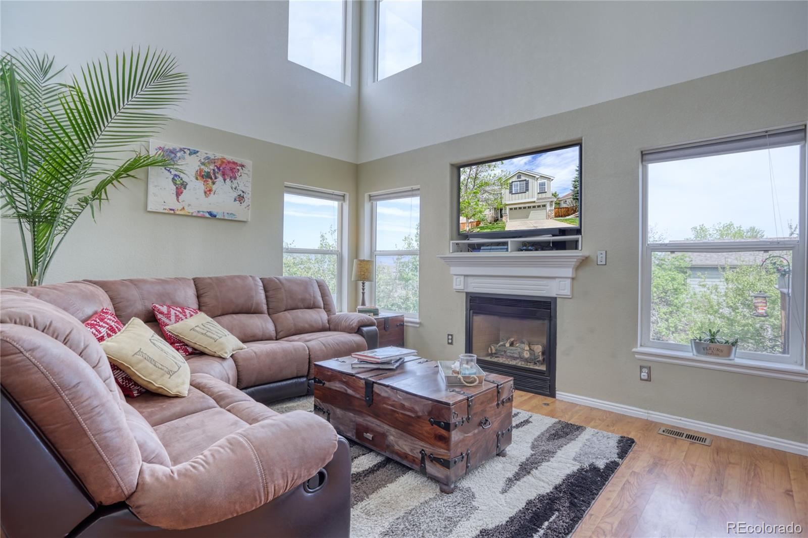659 Timbervale Trail Highlands Ranch, CO 80129 - Photo 3 of 32 a living room with furniture a large window and a fireplace