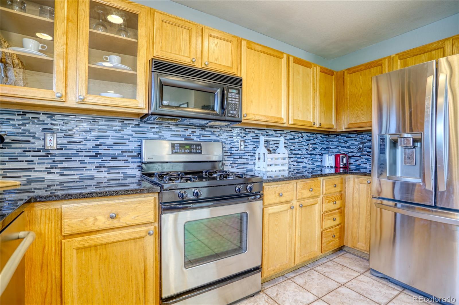 659 Timbervale Trail Highlands Ranch, CO 80129 - Photo 10 of 32 a kitchen with stainless steel appliances granite countertop cabinets and a stove top oven