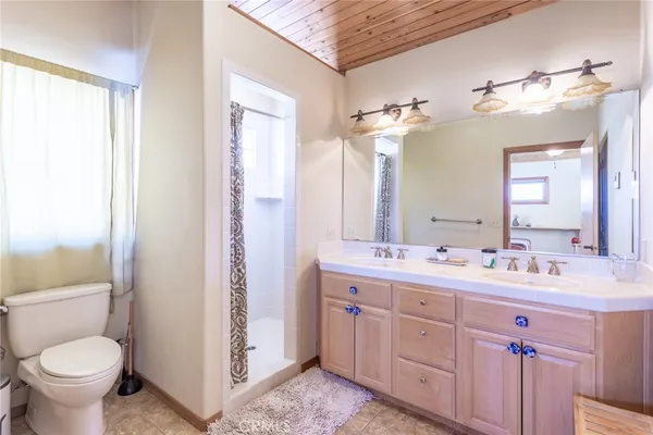 a bathroom with a double vanity sink toilet and a mirror